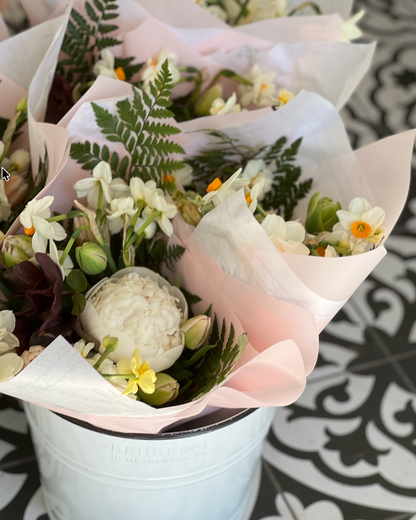 Bouquets of flowers wrapped in white paper on a patterned surface