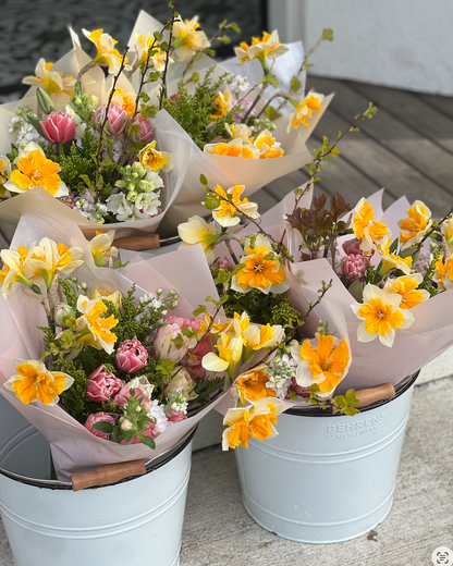 Bouquets of flowers in white buckets on a concrete surface